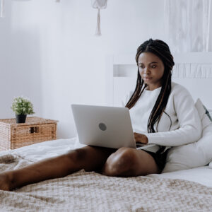 Girl on bed studying with laptop